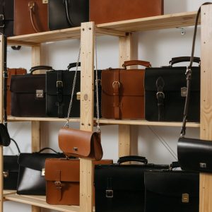 A stylish selection of leather bags showcased on wooden shelves, emphasizing luxury fashion accessories.