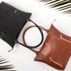 Luxury black and brown leather handbags with crocodile texture, perfect for fashion and lifestyle.