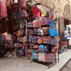 Vibrant handmade bags displayed at an outdoor market offering a variety of traditional designs.