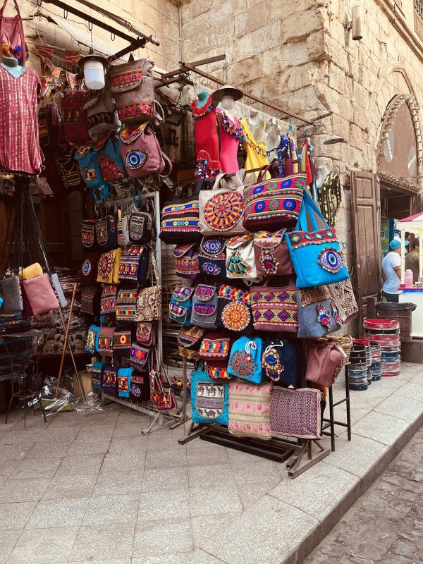 Vibrant handmade bags displayed at an outdoor market offering a variety of traditional designs.